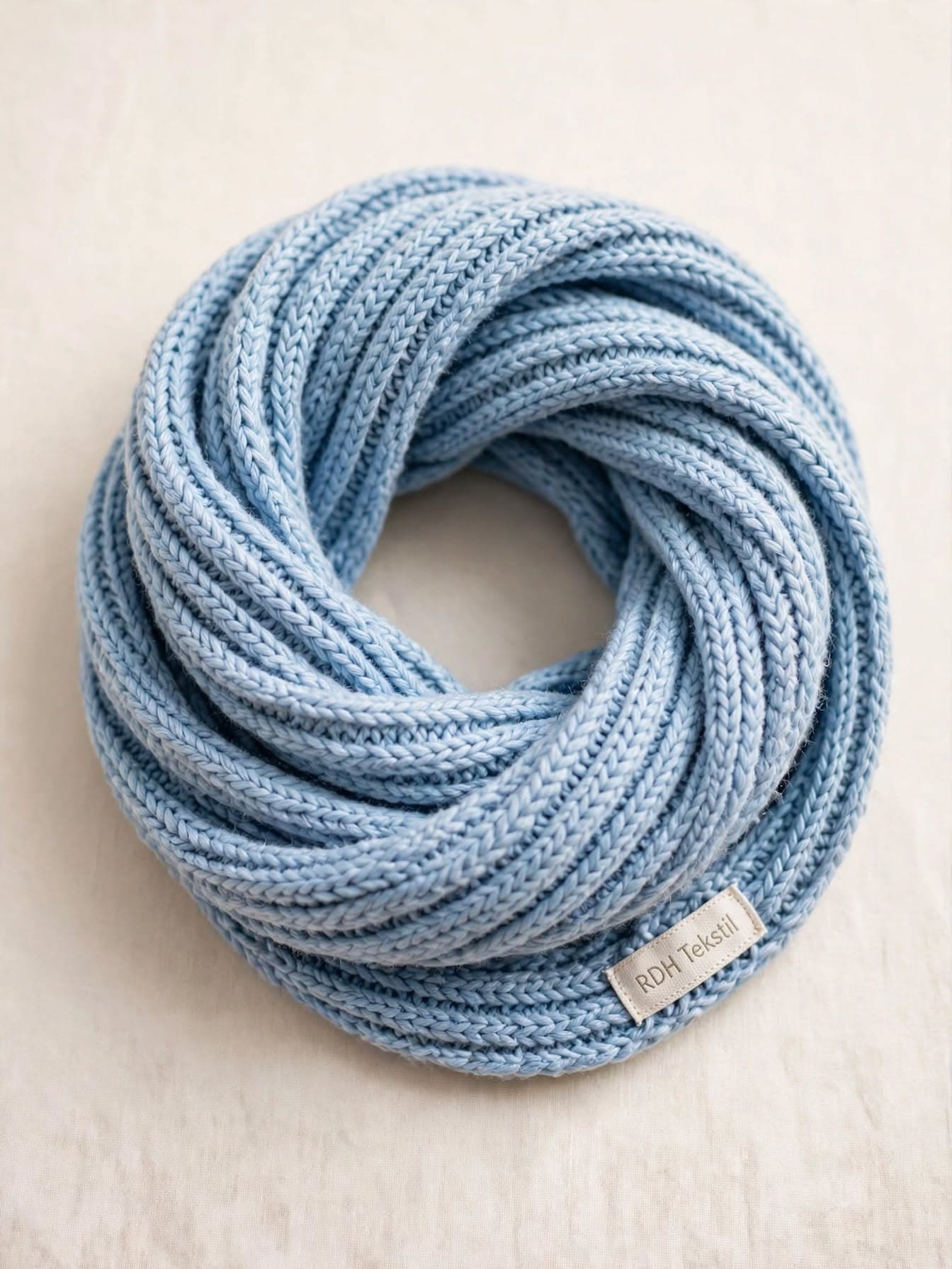 Light blue ribbed kids' scarf with a woven label